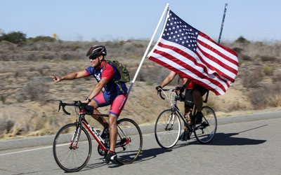 A cyclist with Team RWB brings Old Glory to Camp Pendleton.