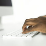 Cropped hands of businessman using computer on table