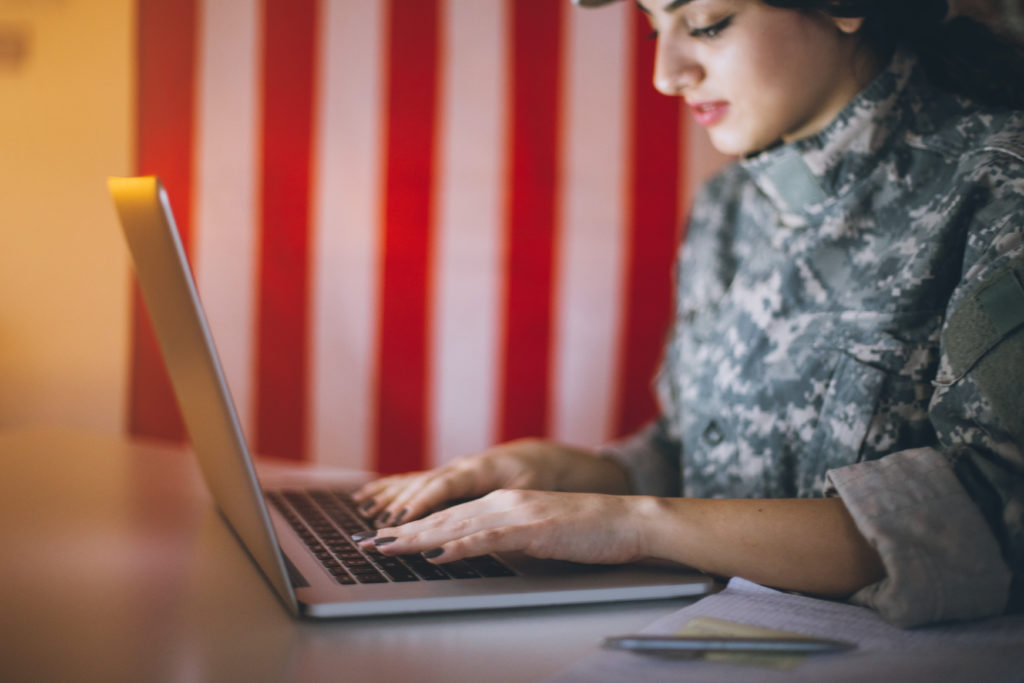 Young soldier woman using a computer into her office in military building