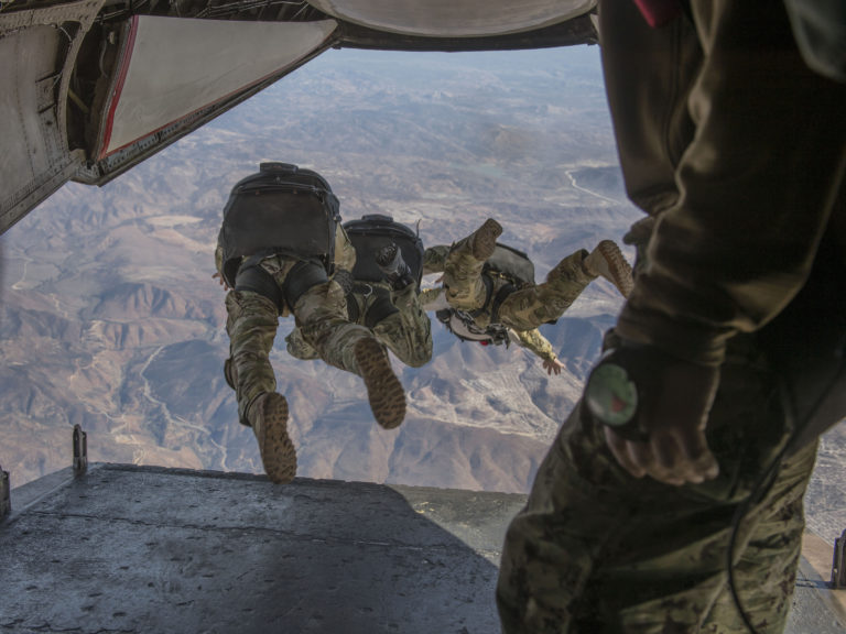 Sailors jump out of a C2-A Greyhound.