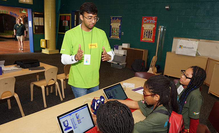 Students at Fort Meade work on the Ohbot robot with a volunteer from Microsoft.