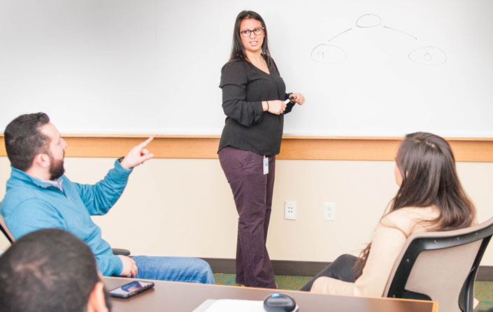 Microsoft mentor, Gina Kirby, advises MSSA students using the whiteboard.