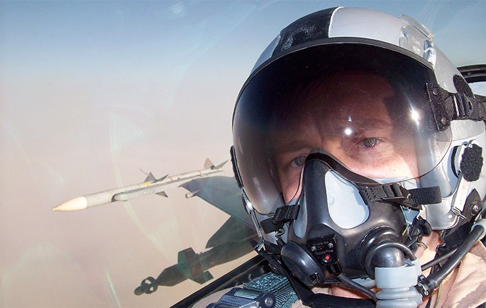 Mark Valentine, pilot with the Air Force, poses for photo while in the air.