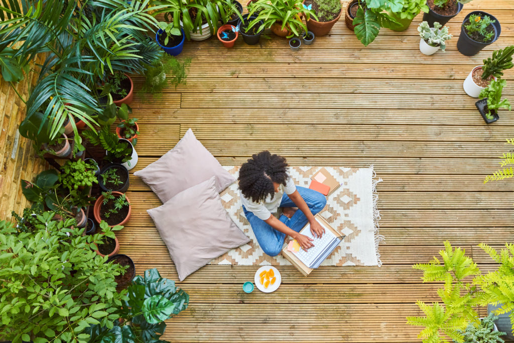 Woman sitting in her garden using a laptop