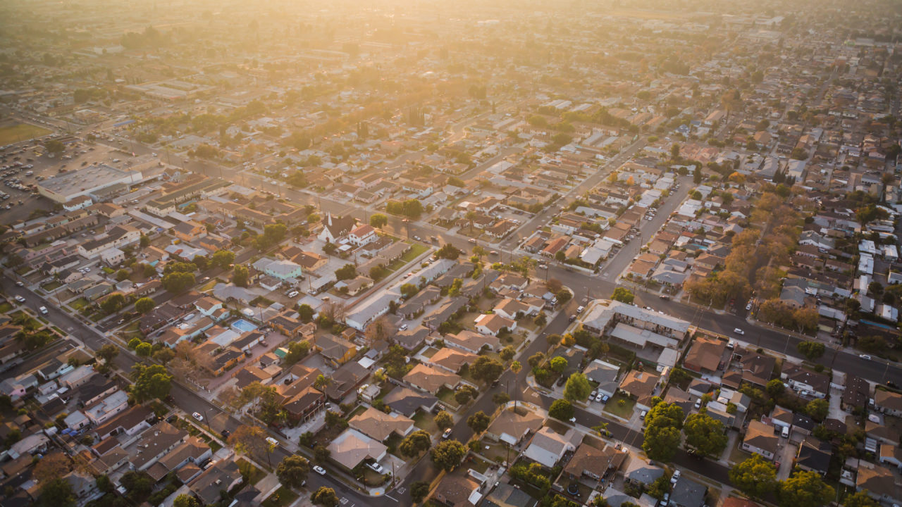 Aerial view of a Southern California neighborhood at sunset with a hazy atmospheric gradient.