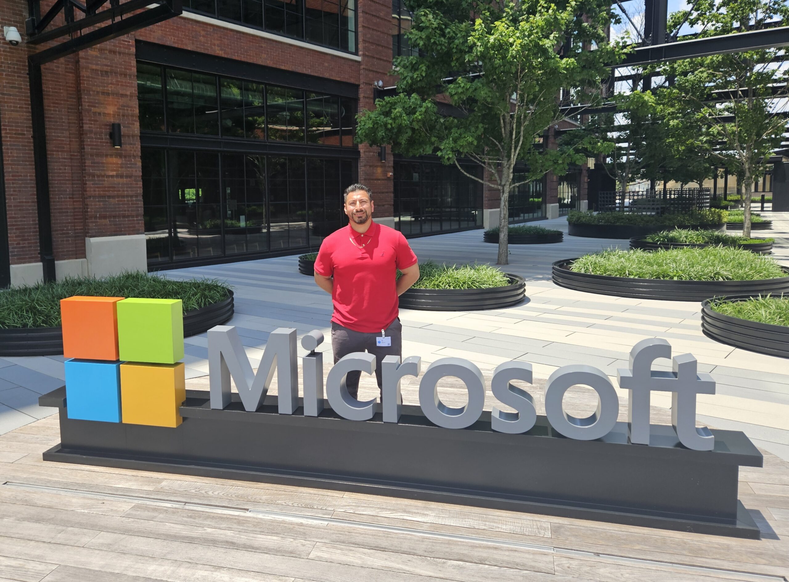 Man stands behind Microsoft Corporate campus logo